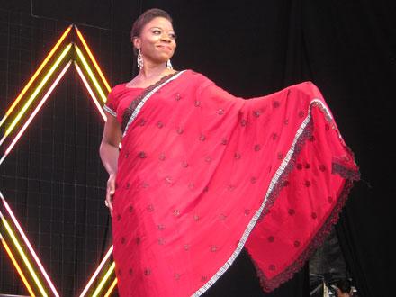 Woman in red traditional clothing presenting on stage